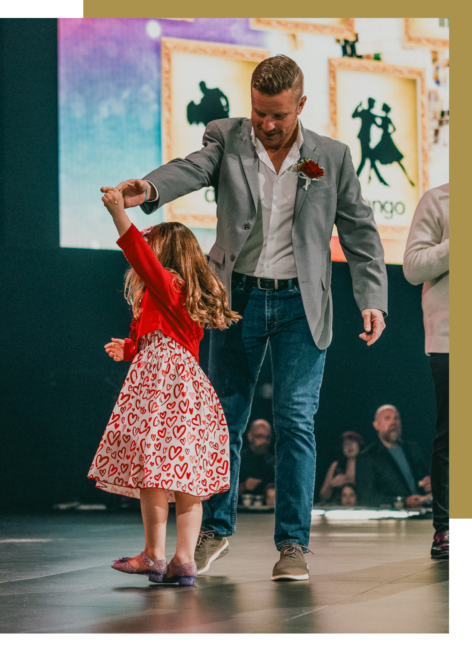 A dad twirling his daughter on stage