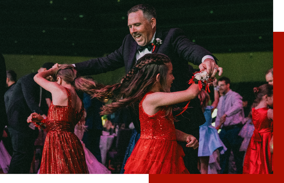 Dads and daughters in red dresses dancing